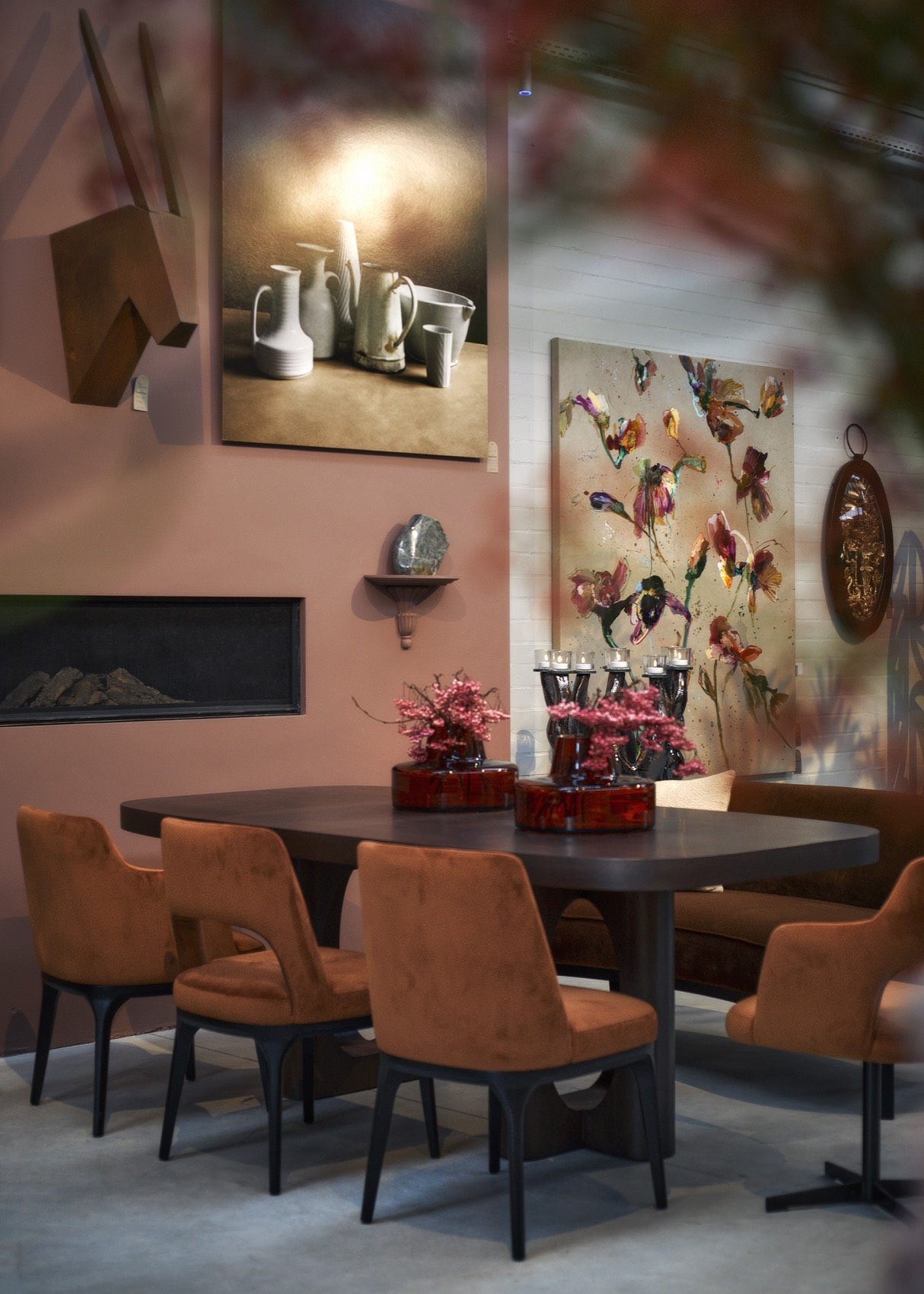 Eethoek met cognackleurige stoelen voor een roze wand