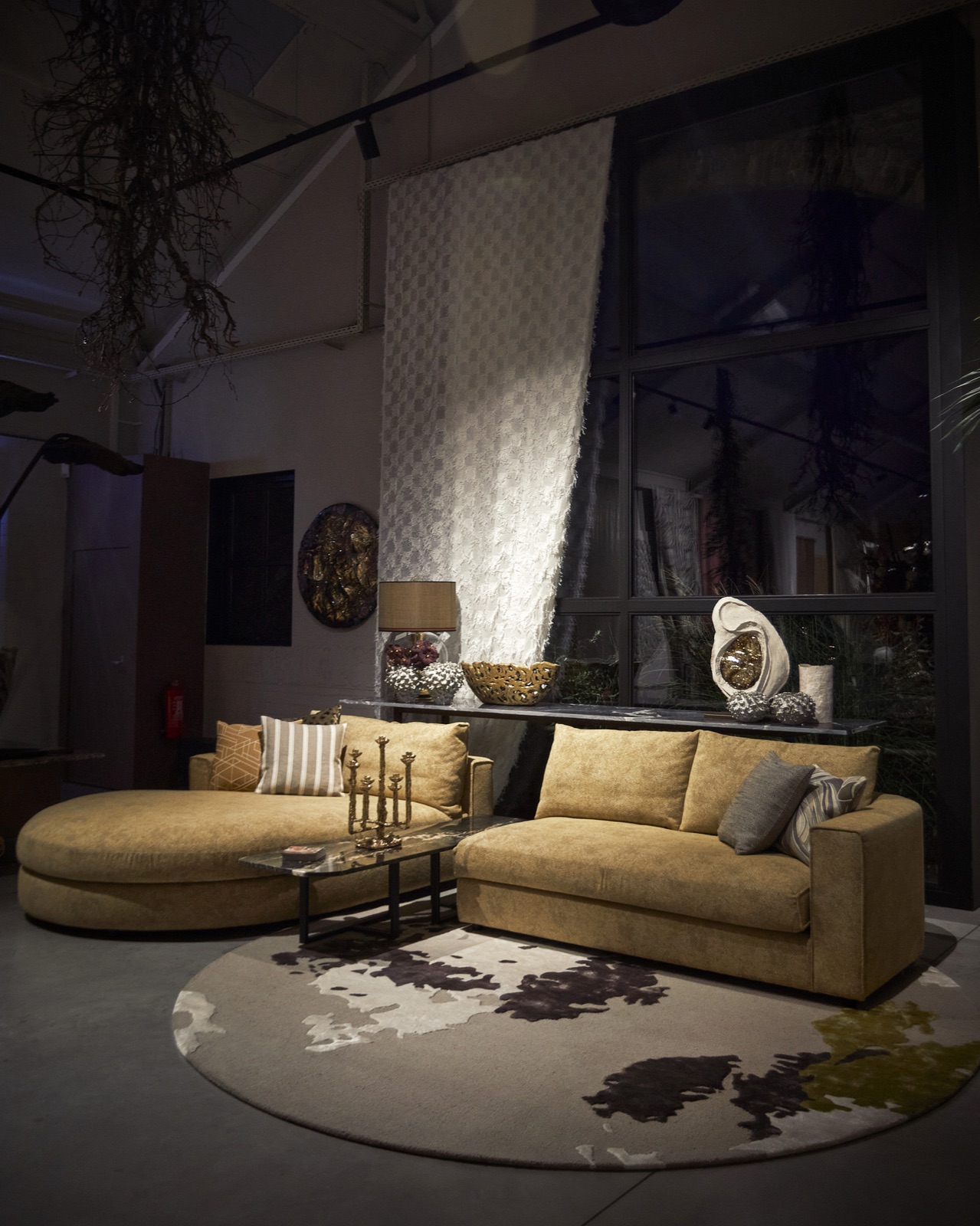 Ronde okergele bank op een rond vloerkleed in de showroom